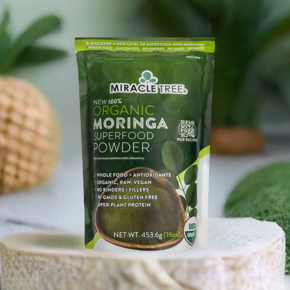 
                  
                    A green-and-white Miracle Tree 100% Organic Moringa Pouch is centered, highlighting its organic, raw, vegan qualities while being GMO- and gluten-free. The pouch sits against a blurred plant backdrop.
                  
                