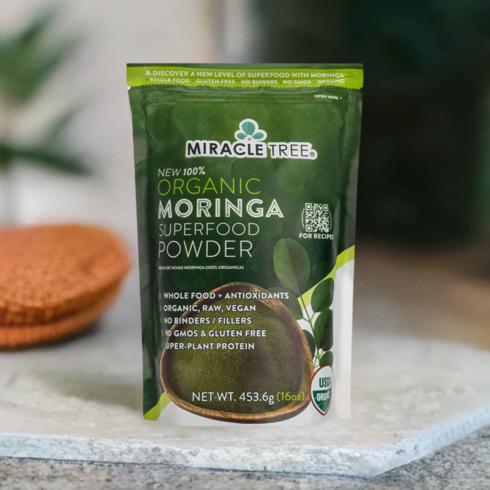 
                  
                    A Miracle Tree 100% Organic Moringa Pouch in green sits on a kitchen counter, highlighting its organic, non-GMO, gluten-free, and vegan nature. A QR code is prominently displayed on the right side for easy scanning.
                  
                